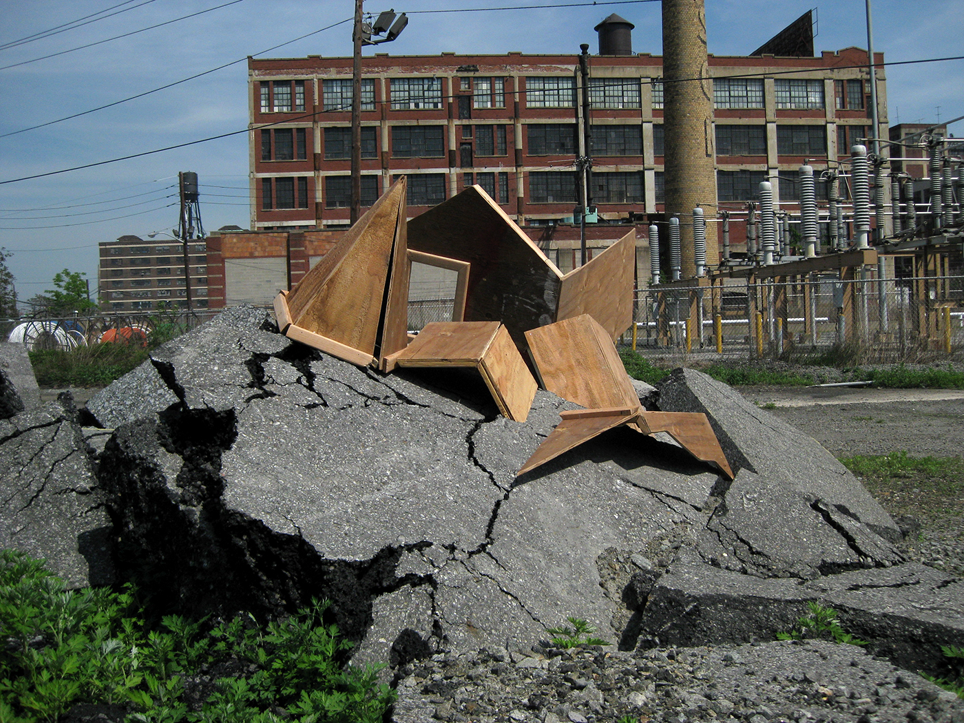 Broken plywood house parts intermingled with rubble