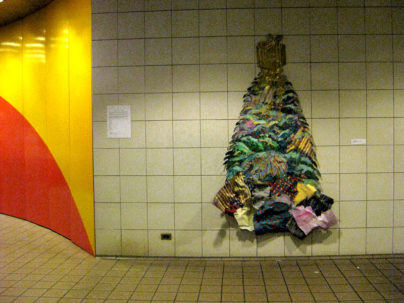 Giant colorful holiday tree sculpture attached to a subway wall in NYC