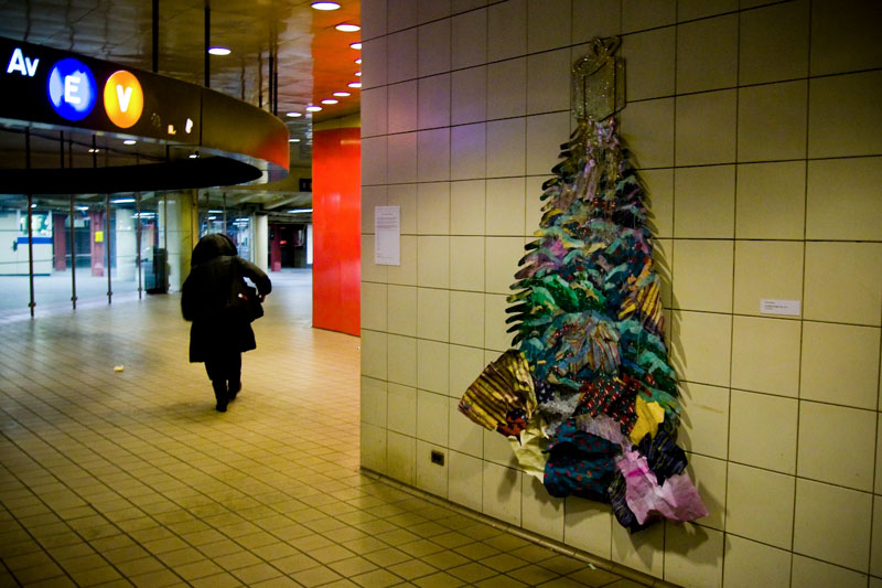 Large colorful holiday tree sculpture on a NYC subway wall